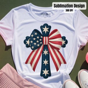 May include: White t-shirt featuring a patriotic design. The design includes a cross-shaped bow with red and white stripes, blue sections with white stars, and additional white star accents. The text "Sublimation Design 300 DPI" is visible.