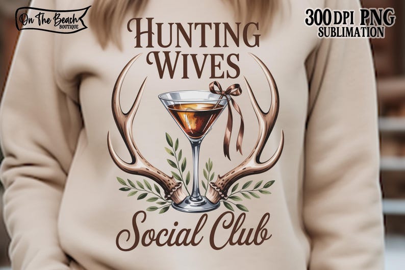 May include: A beige sweatshirt with a graphic featuring a martini glass, antlers, and the text "Hunting Wives Social Club." The design includes brown and green accents, and the words "300 DPI PNG Sublimation" are also visible.