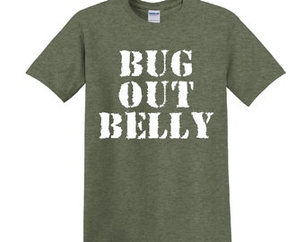 以下が含まれることがあります： 白い文字で「BUG OUT BELLY」とプリントされた緑色のTシャツです。