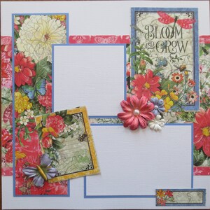 May include: A scrapbook page with floral and butterfly designs. The page features a central white space framed by blue borders and decorated with colorful flowers, butterflies, and the text "BLOOM AND GROW". Decorative paper with floral patterns and butterflies.