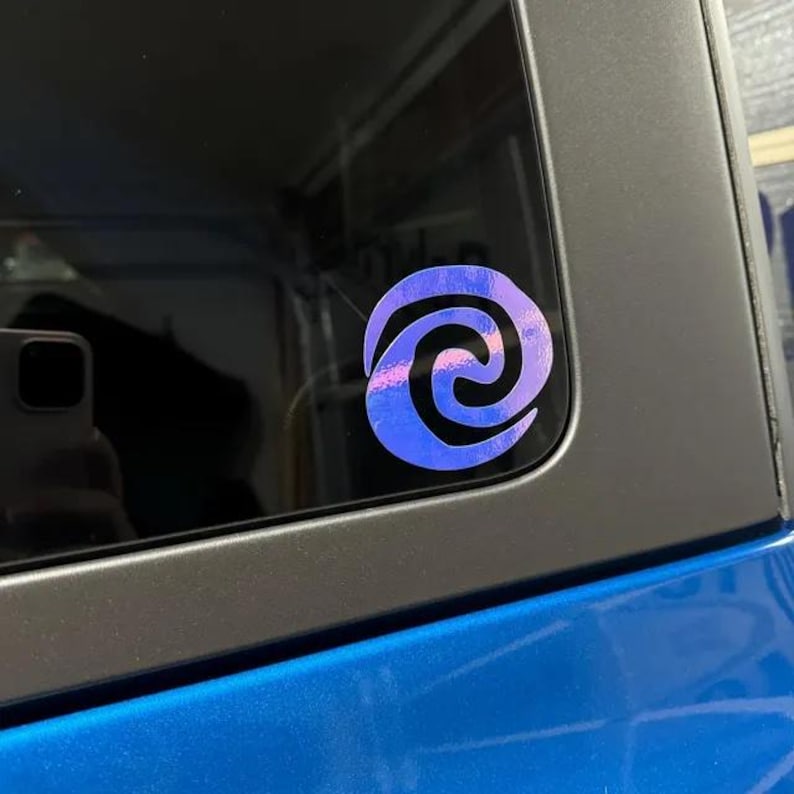May include: A purple and blue swirl decal on a car window. The swirl is a popular symbol from the Disney movie Moana.