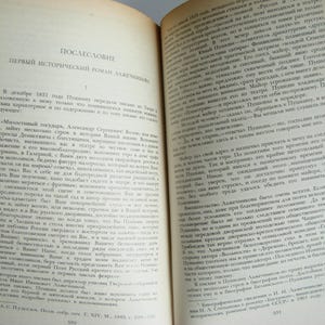 May include: A close-up of a page from a book with the title "POSLESLOVIE" and the text "PERVYI ISTORICHESKII ROMAN LAZHECHNIKOVA" printed in black ink on a cream-colored page.