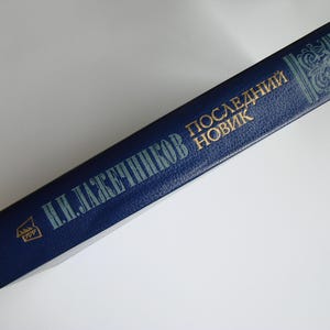 May include: A blue hardcover book with gold lettering. The title is "Последний Новик" by "Н. И. ЛАЖЕЧНИКОВ".