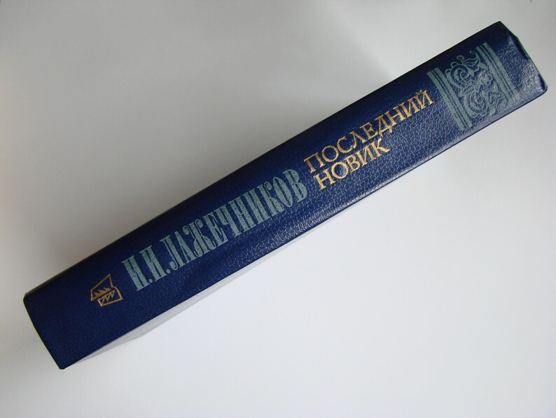 May include: A blue hardcover book with gold lettering. The title is "Последний Новик" by "Н. И. ЛАЖЕЧНИКОВ".