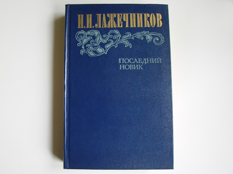 May include: A blue hardcover book with gold lettering on the spine and front cover. The title is "И.Н. ЛАЖЕЧНИКОВ" and "ПОСЛЕДНИЙ НОВИК".