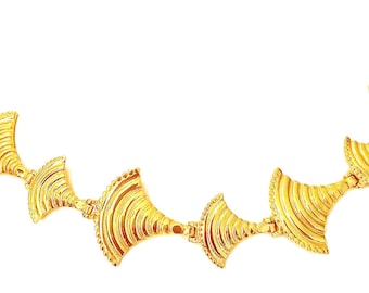 May include: A gold-toned metal necklace featuring a series of repeating fan-shaped links. Each link displays a textured, ribbed surface with a scalloped edge, connected by small hinges to form a continuous, flexible chain structure.