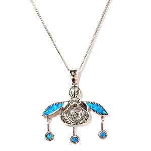 May include: A silver pendant necklace featuring a stylized insect design. The pendant has blue opal accents on the wings and three dangling blue opal beads. The necklace is on a white background.