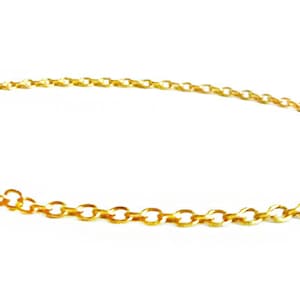 May include: A gold chain bracelet with a round, gold charm. The charm has a small, decorative detail on the side.