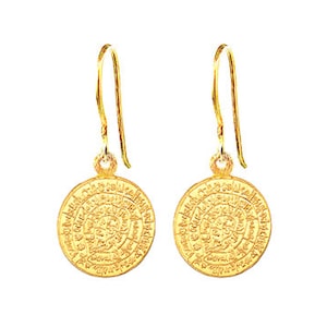 Può includere: Un paio di orecchini pendenti in oro con un design circolare che presenta dettagli intricati. Gli orecchini hanno una forma a goccia e sono realizzati in metallo dorato.