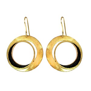 May include: A pair of gold-colored hoop earrings with a textured finish. Each earring features a large outer circle and a smaller inner circle, with a black accent on the inner circle. The earrings have a hook closure.