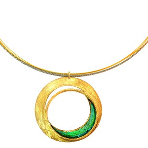 May include: A gold-toned necklace with a large, open circular pendant. The pendant has a textured surface and a smaller inner circle with green and blue accents. The necklace chain is a thin, silver and gold cable.