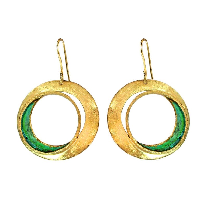 May include: A pair of gold-toned hoop earrings with a textured finish. Each earring features a circular design with a smaller inner circle and a vibrant green enamel accent. The earrings have a hook closure.