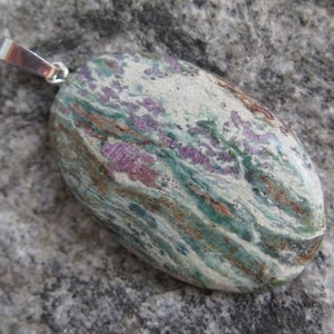 Op de afbeelding: Een zilveren hanger met een ovale steen in groen, wit en roze met een swirl-patroon.