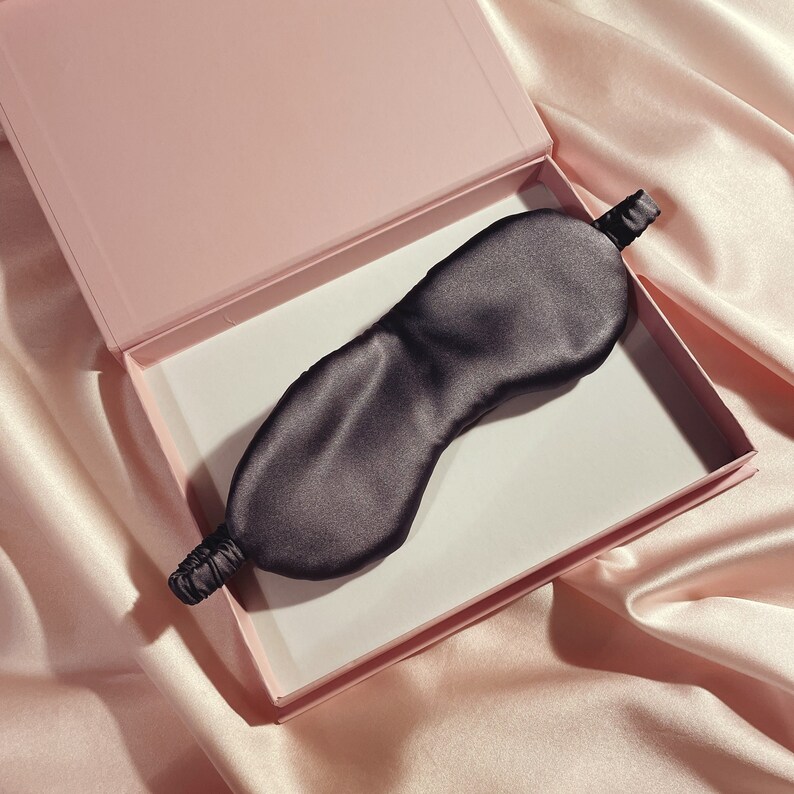 A deep grey silk eye mask in a pink gift box