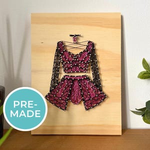 May include: A white ceramic mug with a black handle and the text "But First, Coffee" in a bold, black font. The mug is on a wooden surface. The mug is 10 cm tall.