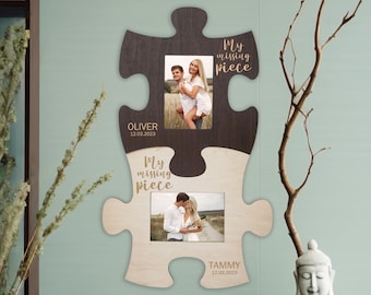May include: A wooden puzzle picture frame with two photo slots. The frame is shaped like two puzzle pieces that fit together. The top piece is brown and the bottom piece is light wood. Each piece has a photo slot and the text "My missing piece" is engraved on each piece. The top piece has the name "Oliver" and the date "12.03.2023" engraved on it. The bottom piece has the name "Tammy" and the date "12.03.2023" engraved on it.