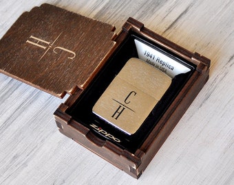 May include: A silver Zippo lighter with the initials "C H" engraved on it. The lighter is in a wooden box with the initials "H C" engraved on the lid. The box has a label that says "1941 Replica Made in USA".