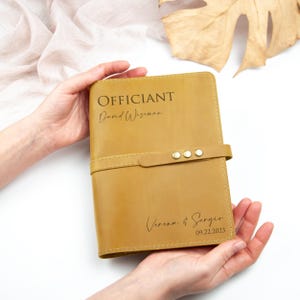a person holding a brown leather journal