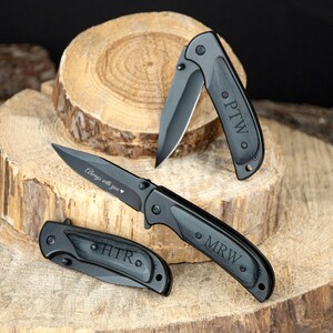 a pair of knifes sitting on top of a tree stump