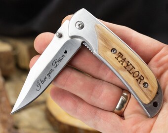 May include: A silver pocket knife with a wood handle. The blade is engraved with "I love you, Brian" and a heart. The handle is engraved with "TAYLOR".