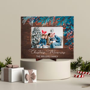 May include: A wooden Christmas-themed picture frame with a family photo. The frame is decorated with blue and red floral accents and the words "Christmas Memories" and "The Millers Family".