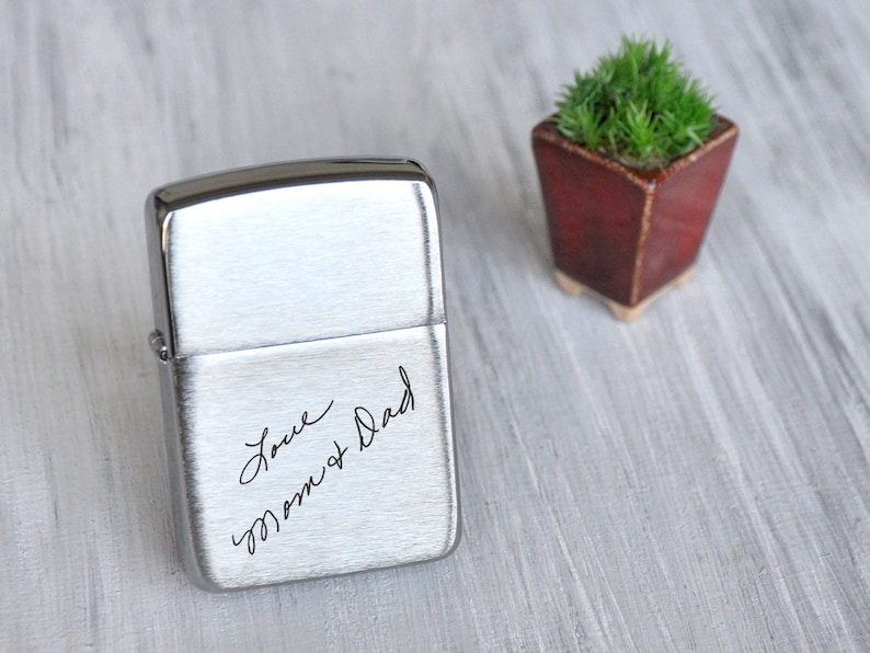 May include: Silver lighter with an engraved message that reads "Love Mom & Dad".