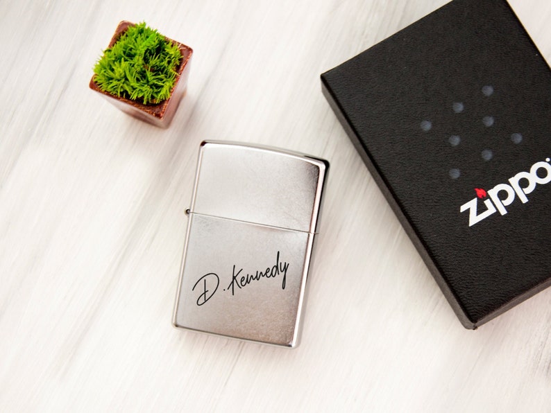 May include: Silver Zippo lighter with a personalized inscription that reads "D. Kennedy".