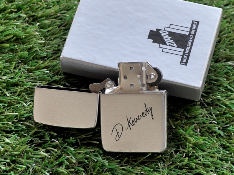 May include: Silver Zippo lighter with a personalized inscription that reads "D. Kennedy".