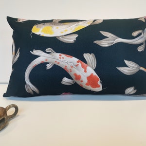 May include: A dark blue throw pillow with a white background featuring a repeating pattern of colorful koi fish.