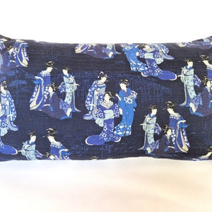 May include: A blue cushion with a repeating pattern of women in traditional Japanese clothing. The cushion is made of a soft, textured fabric.