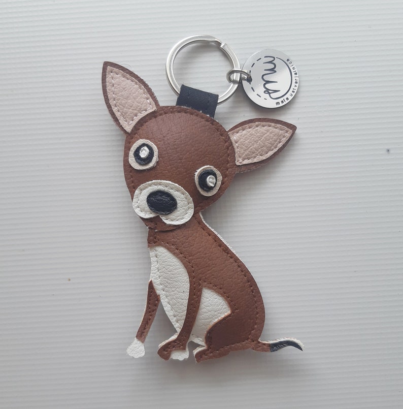 May include: Brown and white leather chihuahua keychain with a silver key ring and a silver tag that says "Made with love,  Mud"