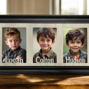 May include: A black framed photo display with three individual photo slots. Each slot contains a portrait of a young boy, with the names "Logan", "Colton", and "Hudson" cut out below each photo.