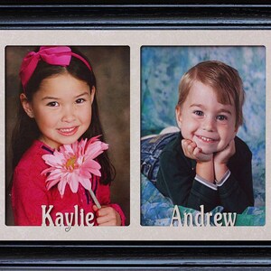 May include: A black picture frame with two openings, each containing a portrait of a child. The girl on the left is holding a pink flower and her name is "Kaylie". The boy on the right is smiling and his name is "Andrew".