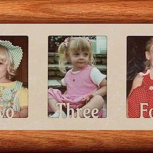 May include: A wooden picture frame with five individual photo slots, each containing a photo of a young girl. The photos are labeled "One", "Two", "Three", "Four", and "Five".