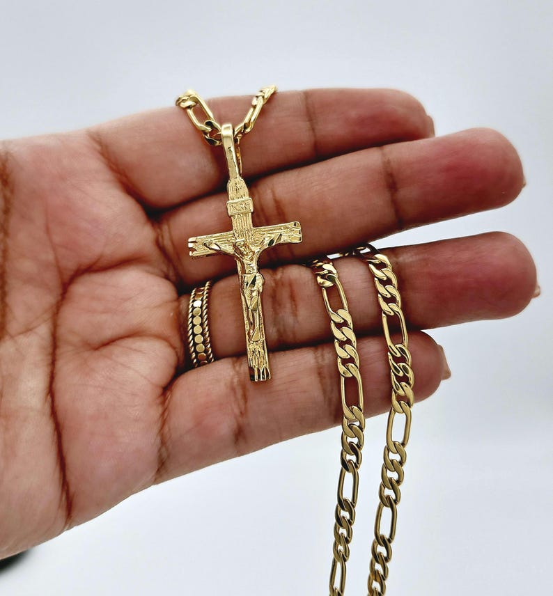 Puede incluir: Un collar de cadena de oro con un colgante de oro de Jes&uacute;s en la cruz.