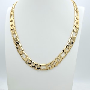 May include: A gold chain necklace with a curb link design. The chain is thick and has a shiny finish.
