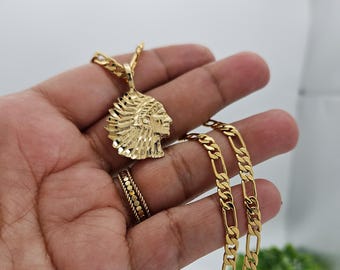 May include: A gold chain necklace with a pendant featuring a detailed profile of a Native American chief wearing a headdress.