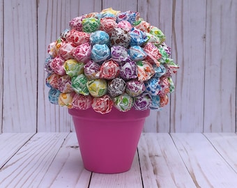 May include: A pink flower pot filled with colorful lollipops, creating a lollipop bouquet.