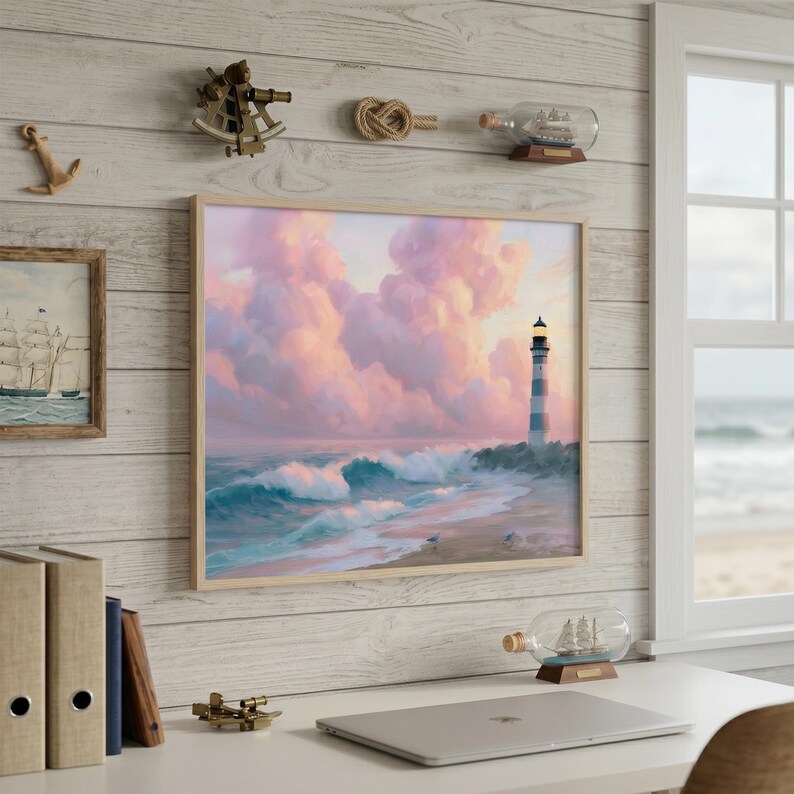 Op de afbeelding: Een ingelijst kustlandschap toont een vuurtoren op een strand met golven onder een roze en paarse lucht. Nautische decoratie omvat een schip in een fles, een touwknoop en een klein messing instrument.