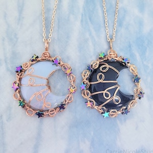 May include: Two crescent moon necklaces with wire wrapped around the moon and iridescent star beads. One moon is white and the other is black.