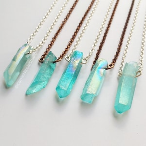 May include: Six iridescent blue crystal pendants on silver and copper chains. The crystals are faceted and have a rainbow sheen.