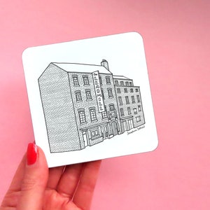 May include: Black and white line drawing of a brick building with a sign that reads "PROPER" on a white background.