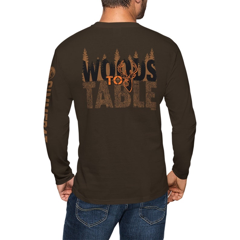 May include: Brown long-sleeve t-shirt with a graphic print of a deer head and the text "Woods to Table" on the back. The shirt has a brown and orange color scheme.