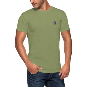 K&ouml;nnte beinhalten: Ein gr&uuml;nes T-Shirt mit kurzen &Auml;rmeln und einem kleinen blauen Grafikdruck einer Person auf der linken Brust.