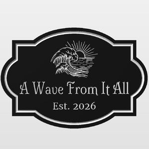 May include: A black rectangular sign with rounded, decorative edges and a white border. The center features a white line-art illustration of a crashing ocean wave and a rising sun. The text reads A Wave From It All and Est. 2026.