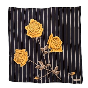 Può includere: Un foulard di seta a righe bianche e nere con un motivo di rose gialle. Il foulard presenta tre rose e un piccolo bocciolo.