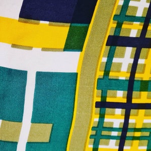 May include: Abstract geometric pattern fabric in yellow, green, white, and navy blue. The fabric has a checkered pattern with a large square in the center.