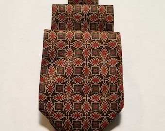 Könnte beinhalten: Eine braune Seidenkrawatte mit einem geometrischen Muster in Rot-, Grün- und Goldtönen.