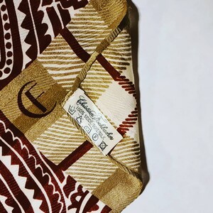 Peut inclure: Un foulard en soie &agrave; motifs marrons et blancs avec une &eacute;tiquette indiquant "Christian Lacroix 100% Seide/Soie/Silk".