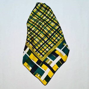 May include: A green, yellow, and black patterned silk scarf with a geometric design.